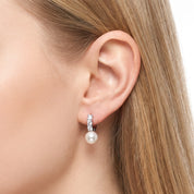 Silver pearl drop huggie earring with a crystal bar on the ear