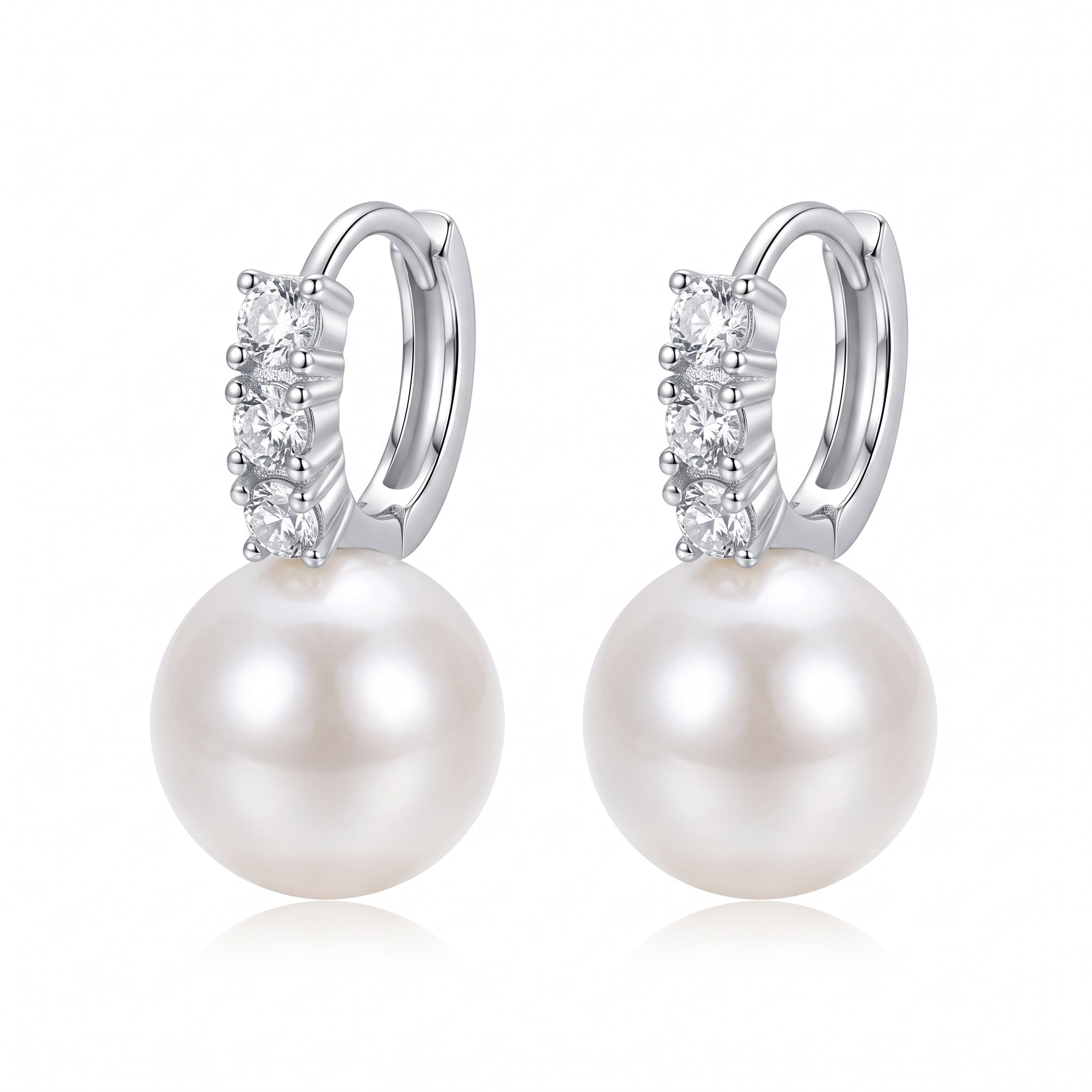 Pair of silver pearl drop huggie earrings on white