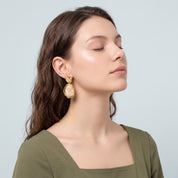 Gold cream resin drop earring worn with an olive green dress