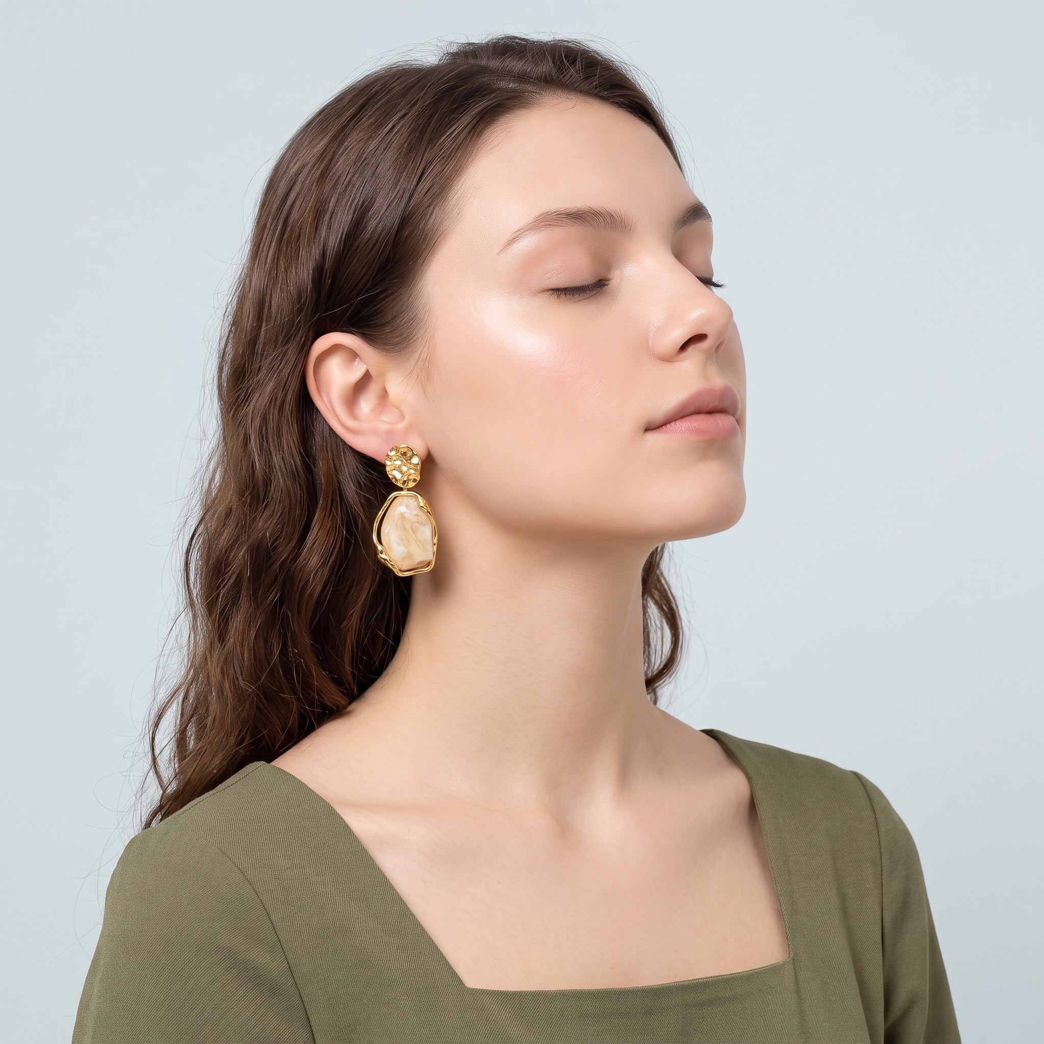 Gold cream resin drop earring worn with an olive green dress