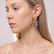 Gold grey resin drop earring in a close beauty portrait