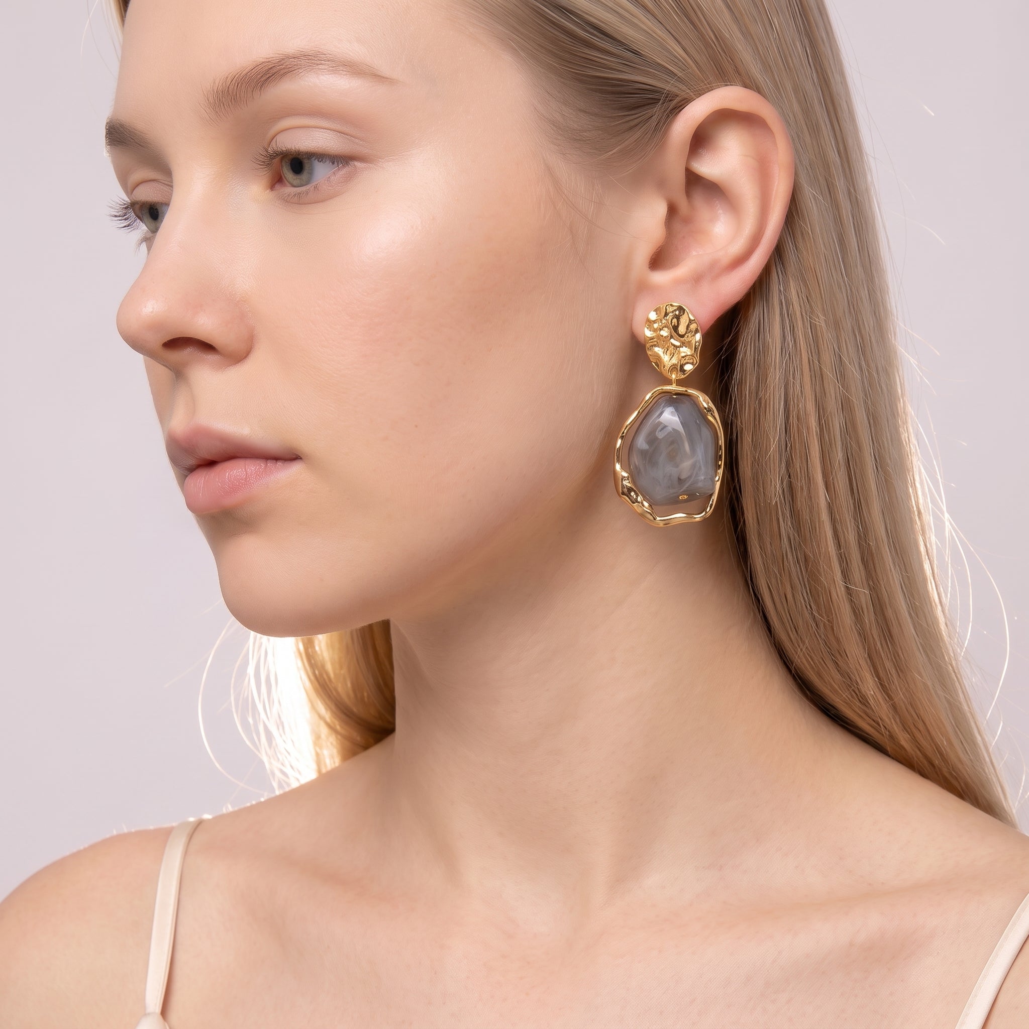 Gold grey resin drop earring in a close beauty portrait