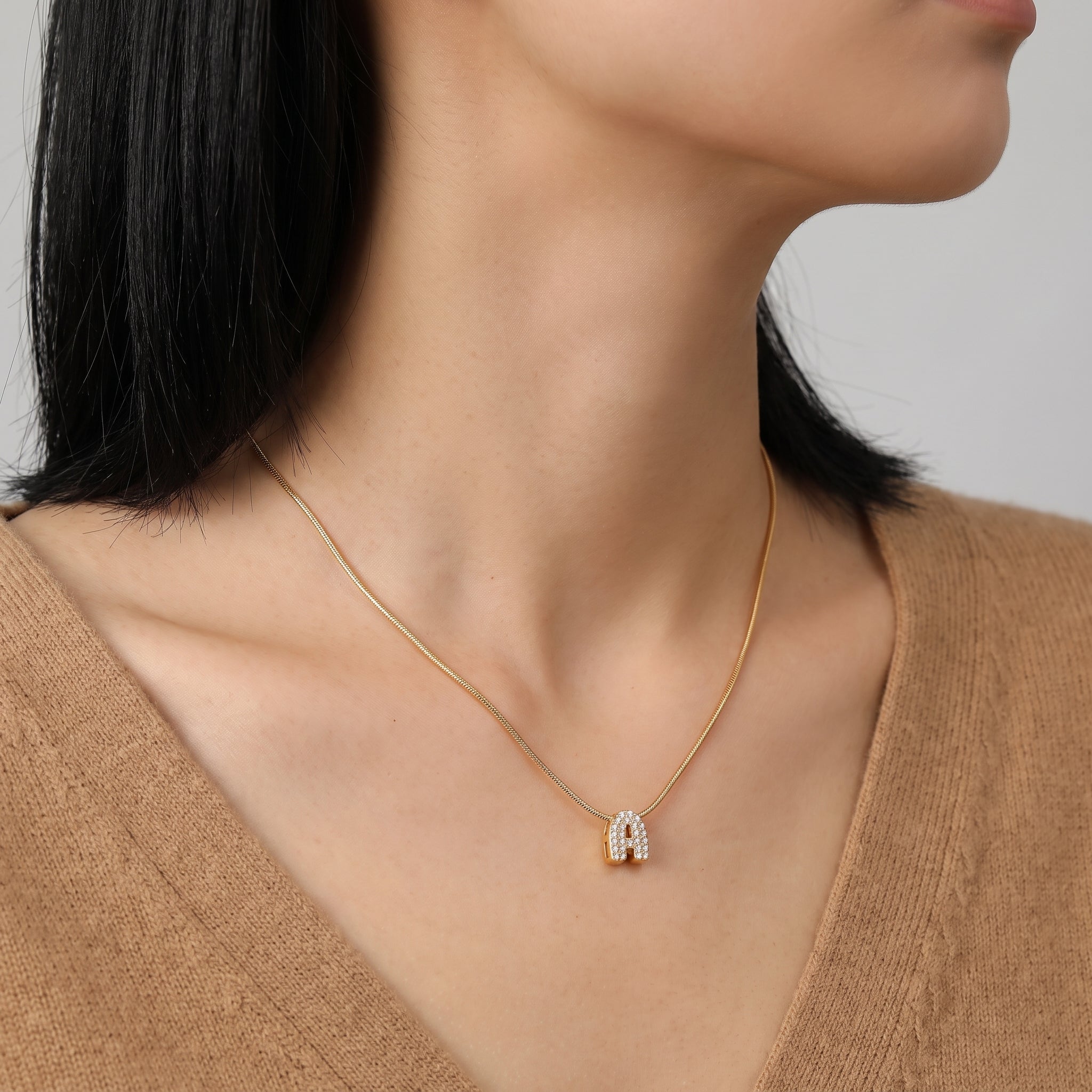 Gold bubble letter necklace, pavé crystal A, worn at the neck
