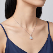 Silver pavé pendant necklace at the collarbone with a navy camisole