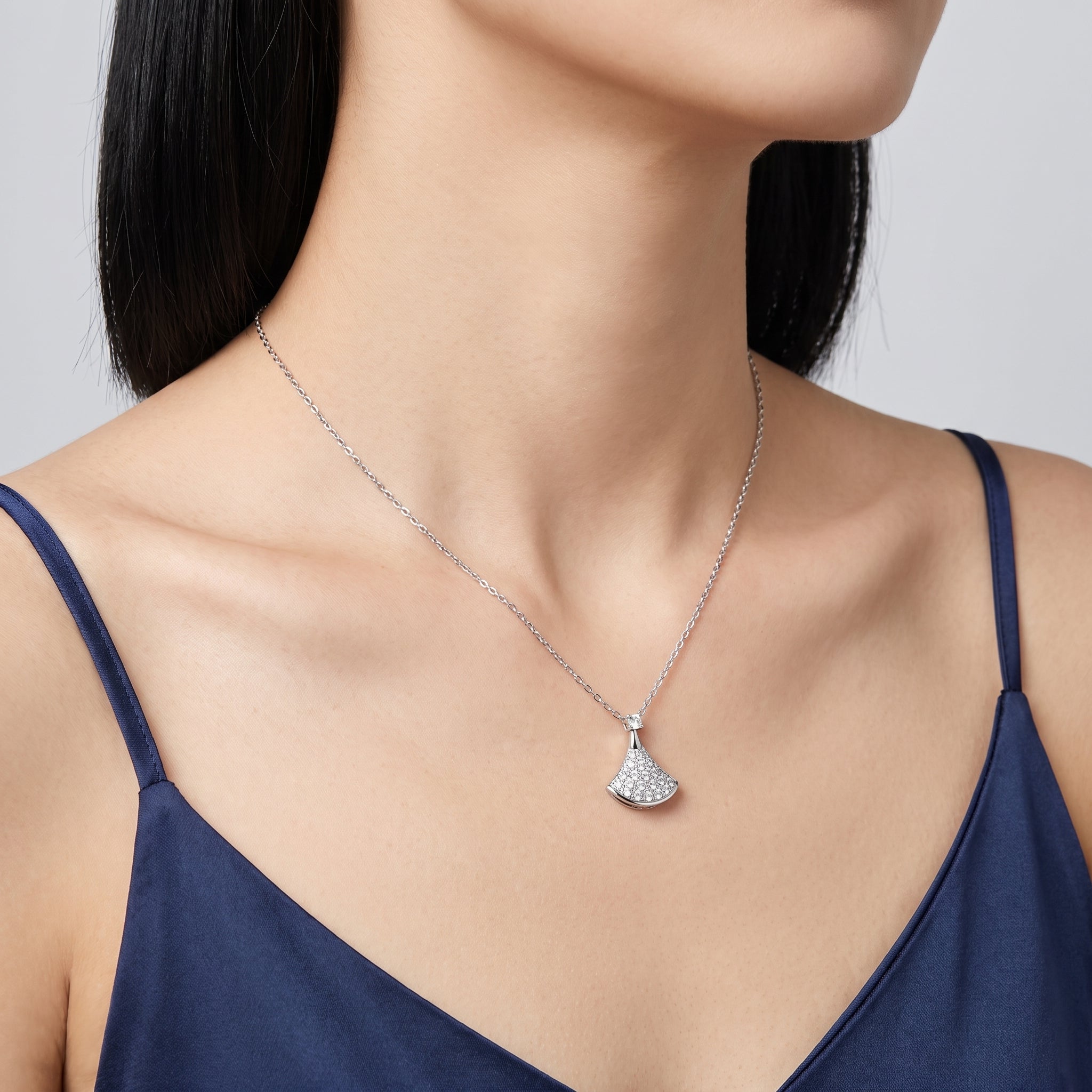 Silver pavé pendant necklace at the collarbone with a navy camisole