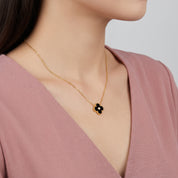 Gold black clover necklace with crystal center worn at the collarbone