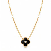 Gold black clover necklace laid flat on white with its cable chain