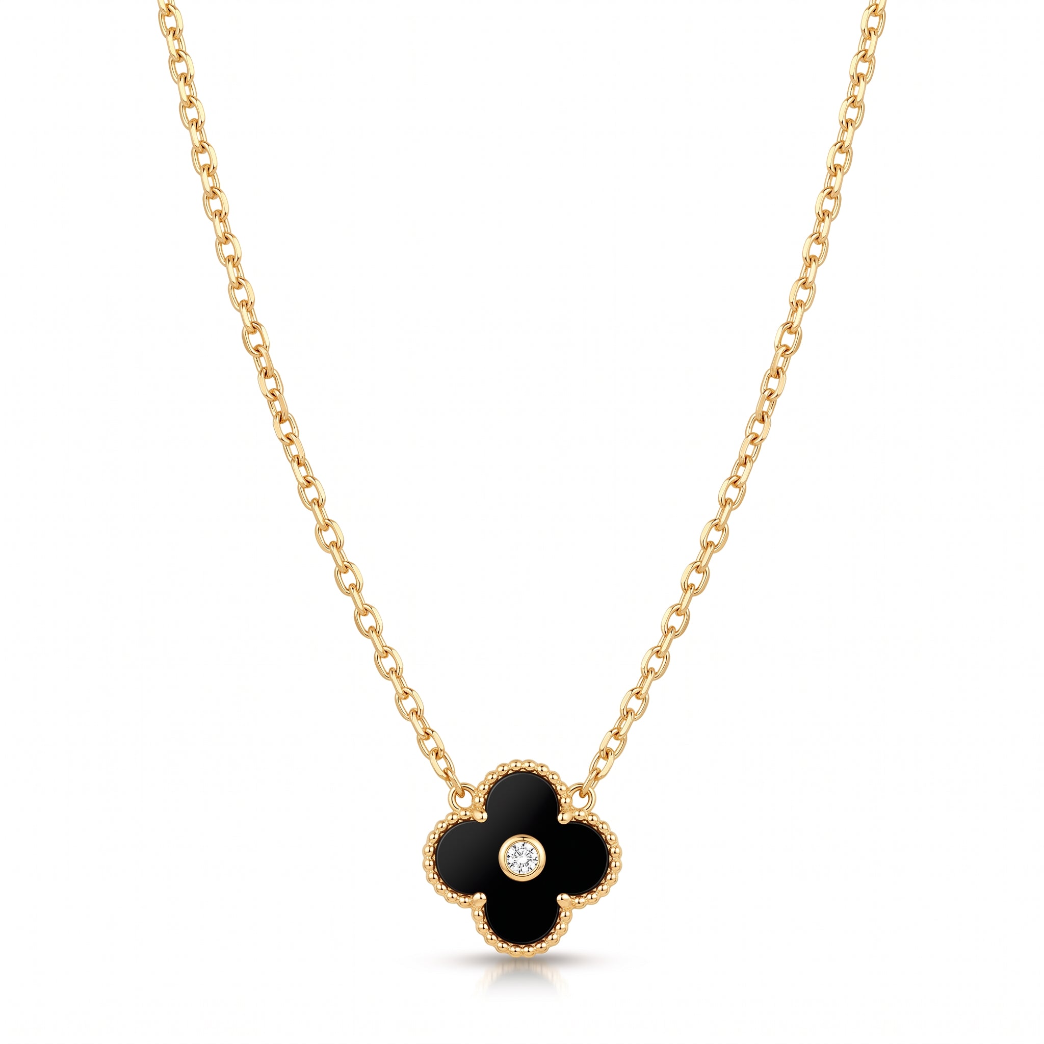 Gold black clover necklace laid flat on white with its cable chain
