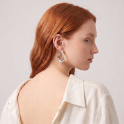 Silver chunky open hoop earring seen over the shoulder