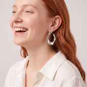 Silver chunky open hoop earring worn with an ivory linen shirt