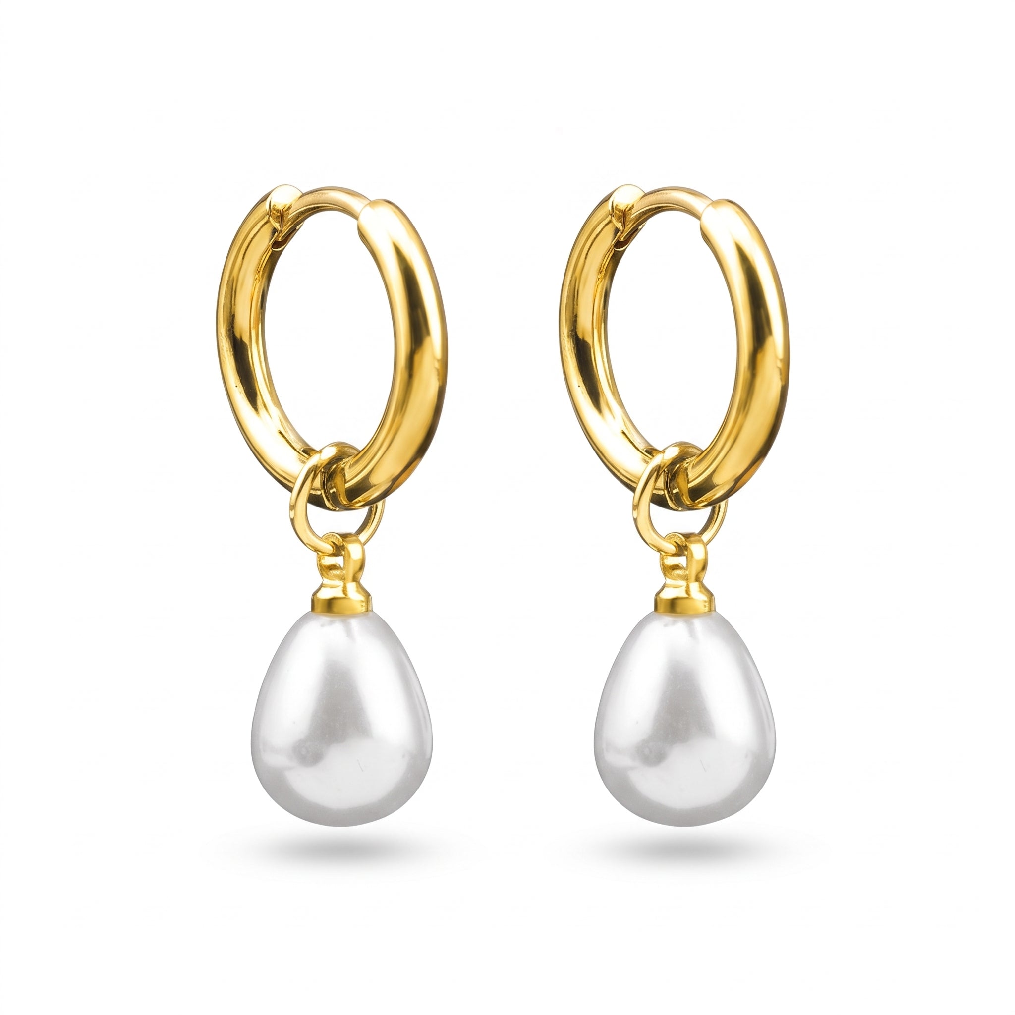 Pair of Odile gold huggie hoops with teardrop pearl drops on white background
