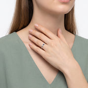 Hand at the collarbone with a silver three stone ring