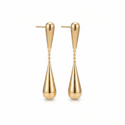 Gold teardrop earrings, pair laid out on a white background