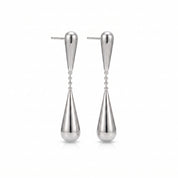 Silver teardrop earrings, pair laid out on a white background