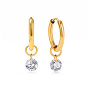 Pair of gold huggie earrings with round crystals on white
