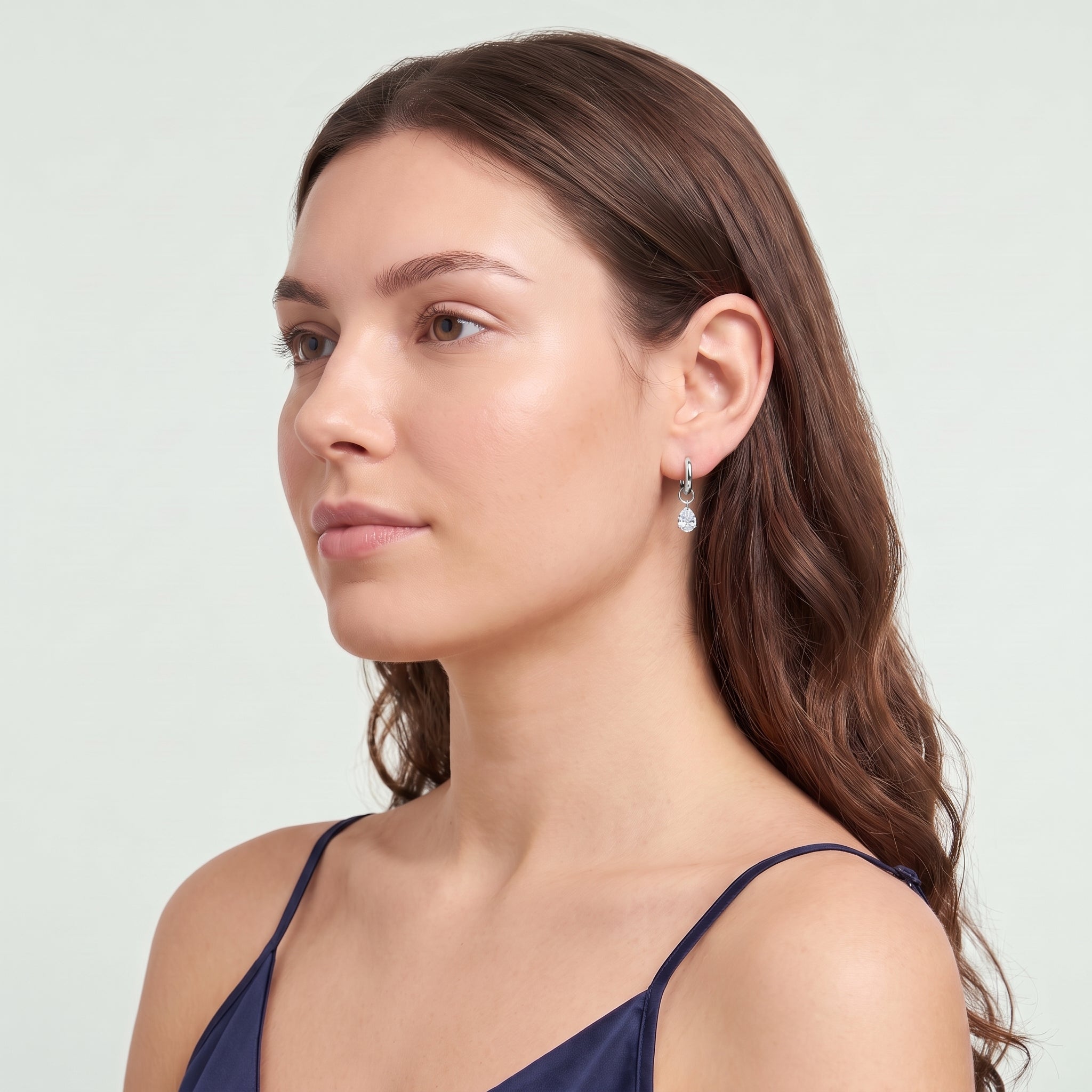 Silver teardrop huggie earring in a serene chin lift