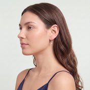 Silver teardrop huggie earring in a sculpted side profile