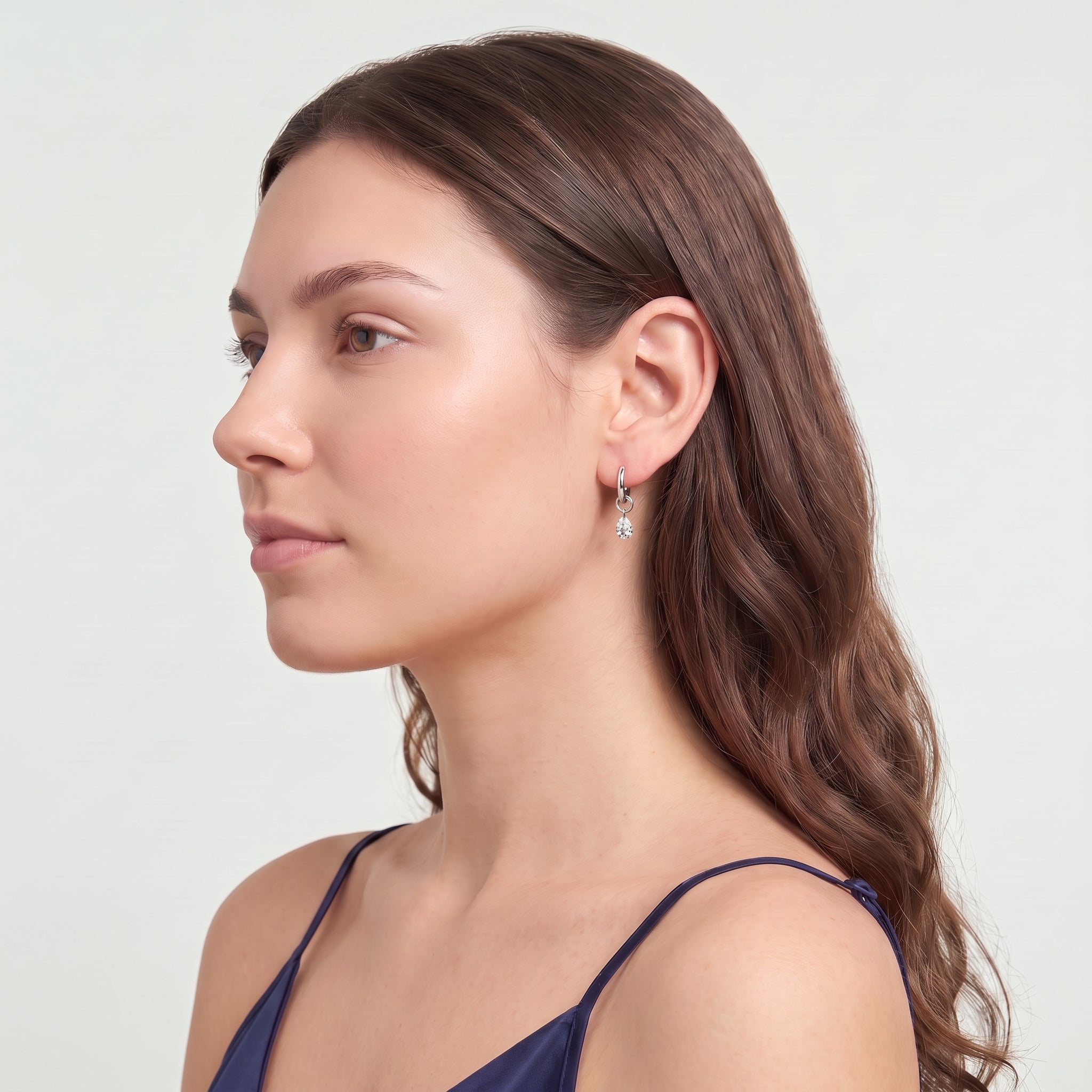 Silver teardrop huggie earring in a sculpted side profile