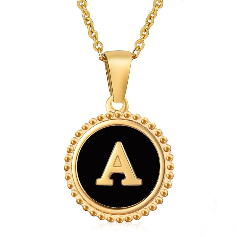 Gold initial necklace with letter A on a round beaded black pendant