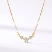 Gold daisy crystal necklace with three flowers hanging on white