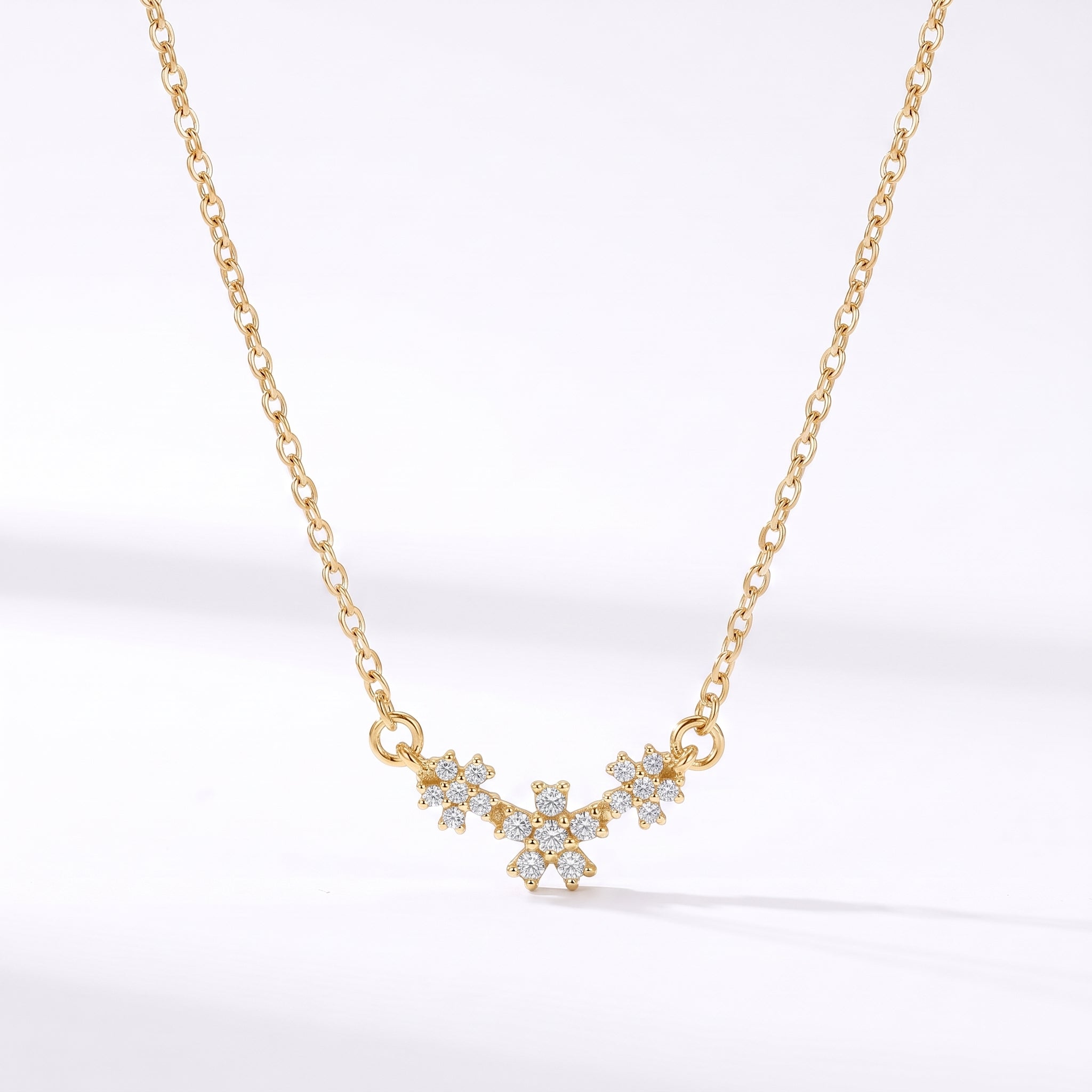 Gold daisy crystal necklace with three flowers hanging on white