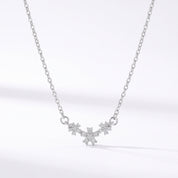 Silver necklace with three crystal daisies on a white background