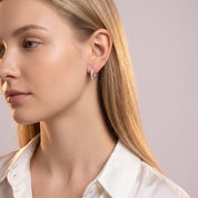 Silver rope huggie earrings worn with a white silk shirt