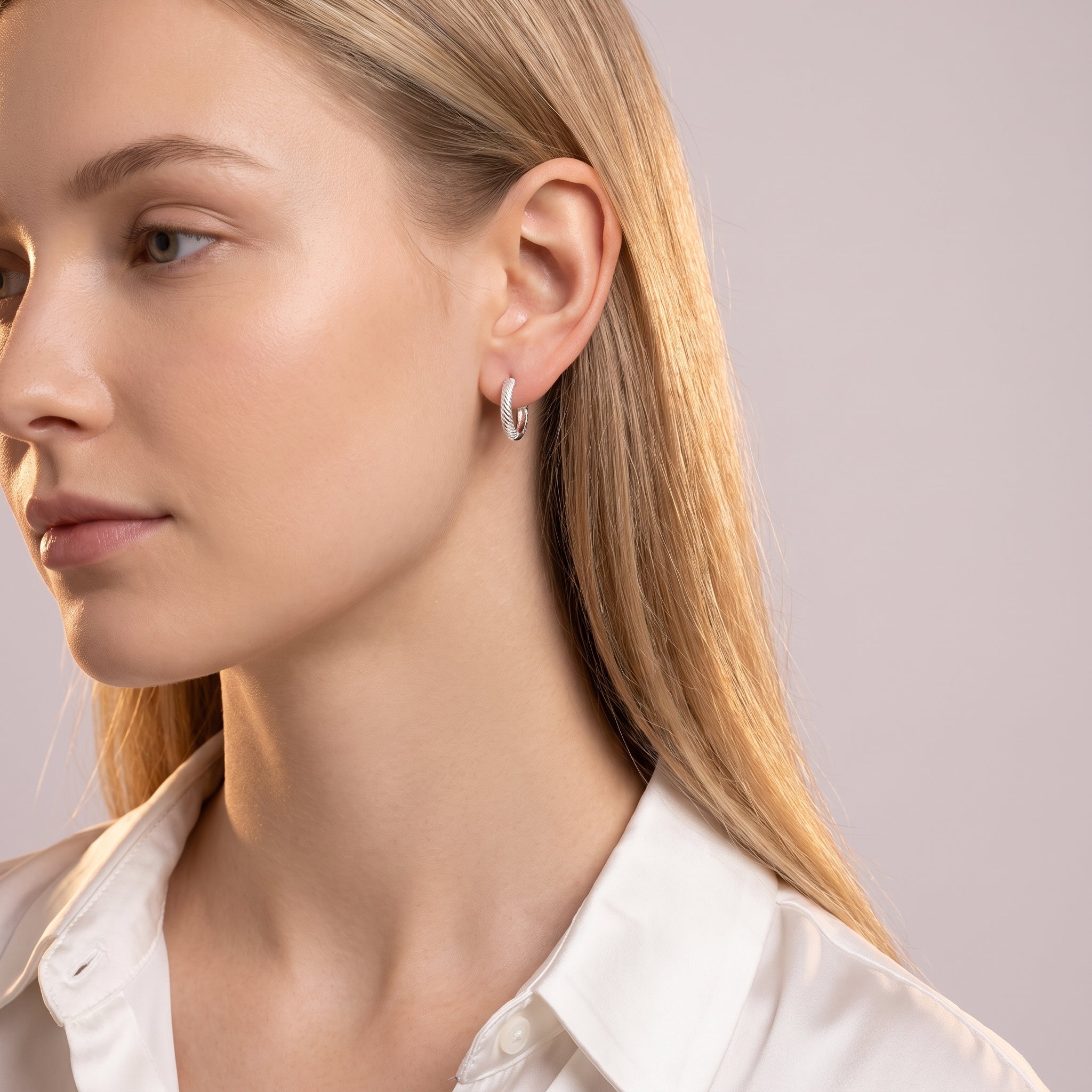 Silver rope huggie earrings worn with a white silk shirt