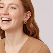 Gold triple hoop earring in a laughing portrait