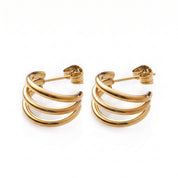 Pair of polished gold triple hoop earrings on white