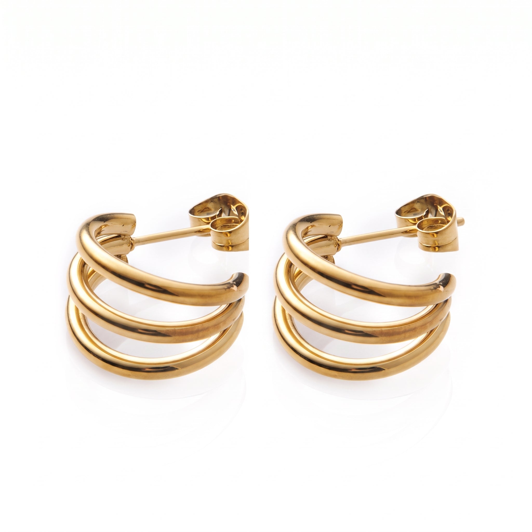 Pair of polished gold triple hoop earrings on white