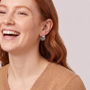 Silver triple hoop earring in a laughing portrait