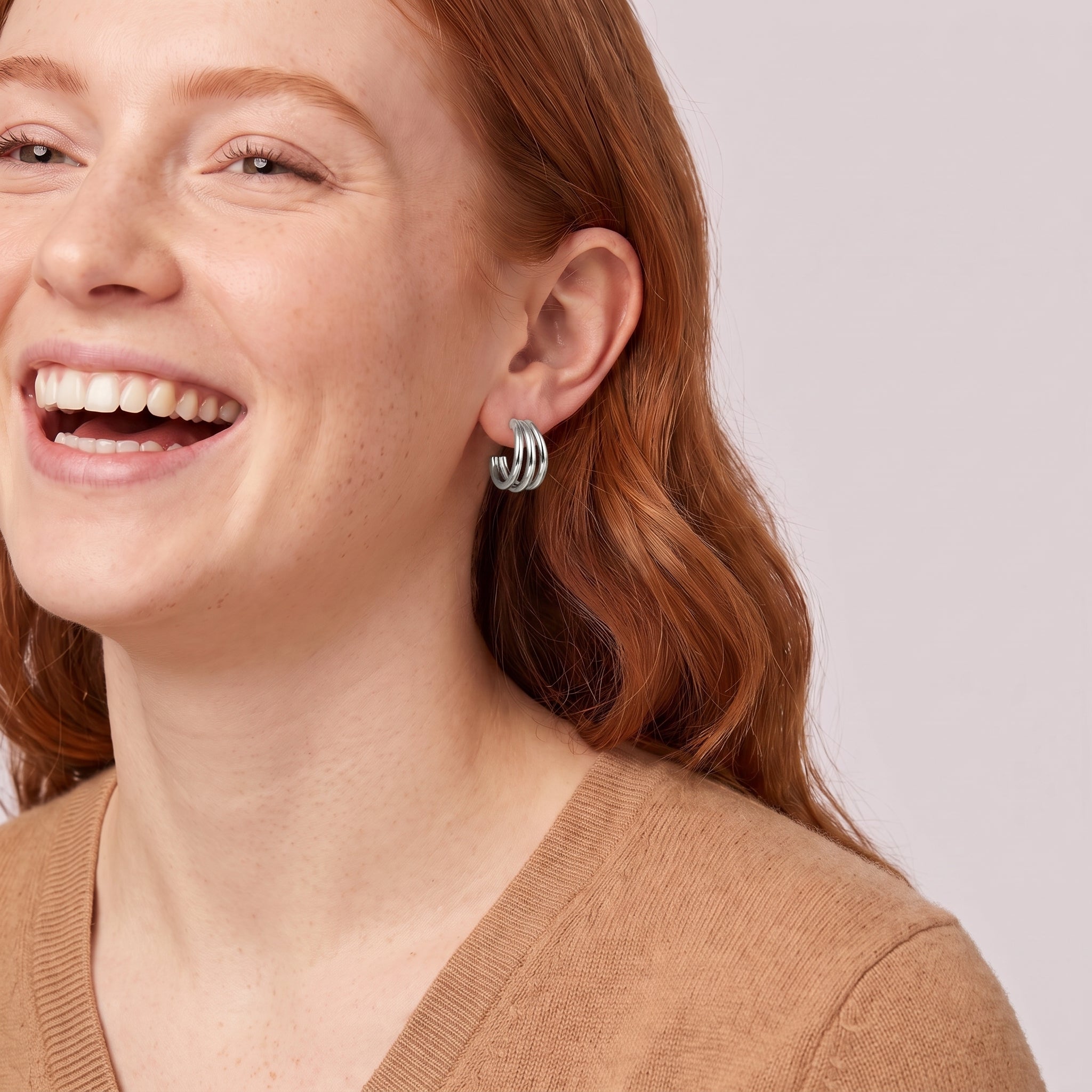 Silver triple hoop earring in a laughing portrait