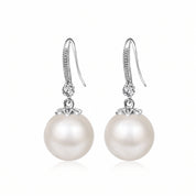 Pair of Sabine silver pearl drop earrings with crystal hooks on white background
