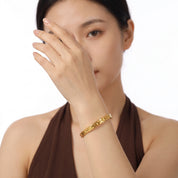 Gold hammered cuff worn with a brown halter top