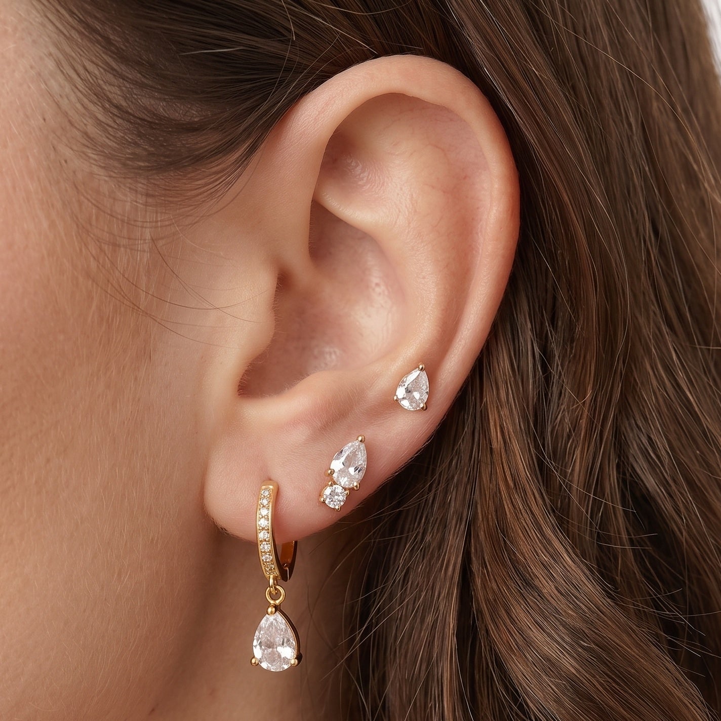 Gold earring set: huggie hoop and pear crystal studs worn stacked