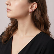 Gold earring set worn stacked, seen in side profile