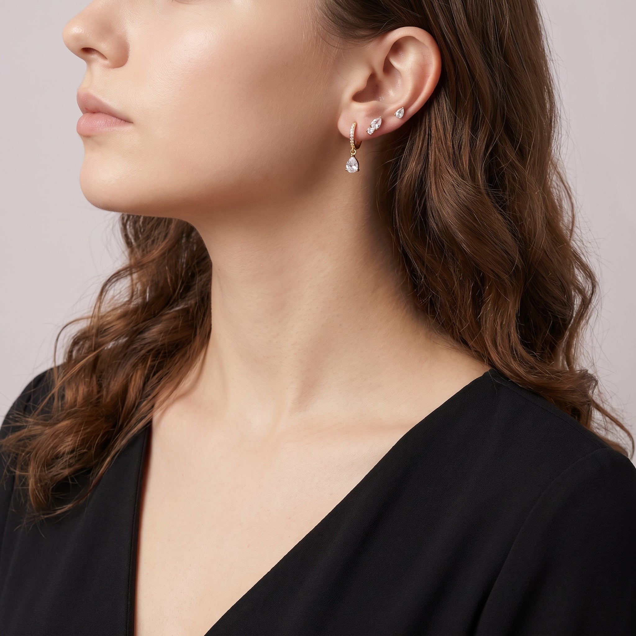 Gold earring set worn stacked, seen in side profile