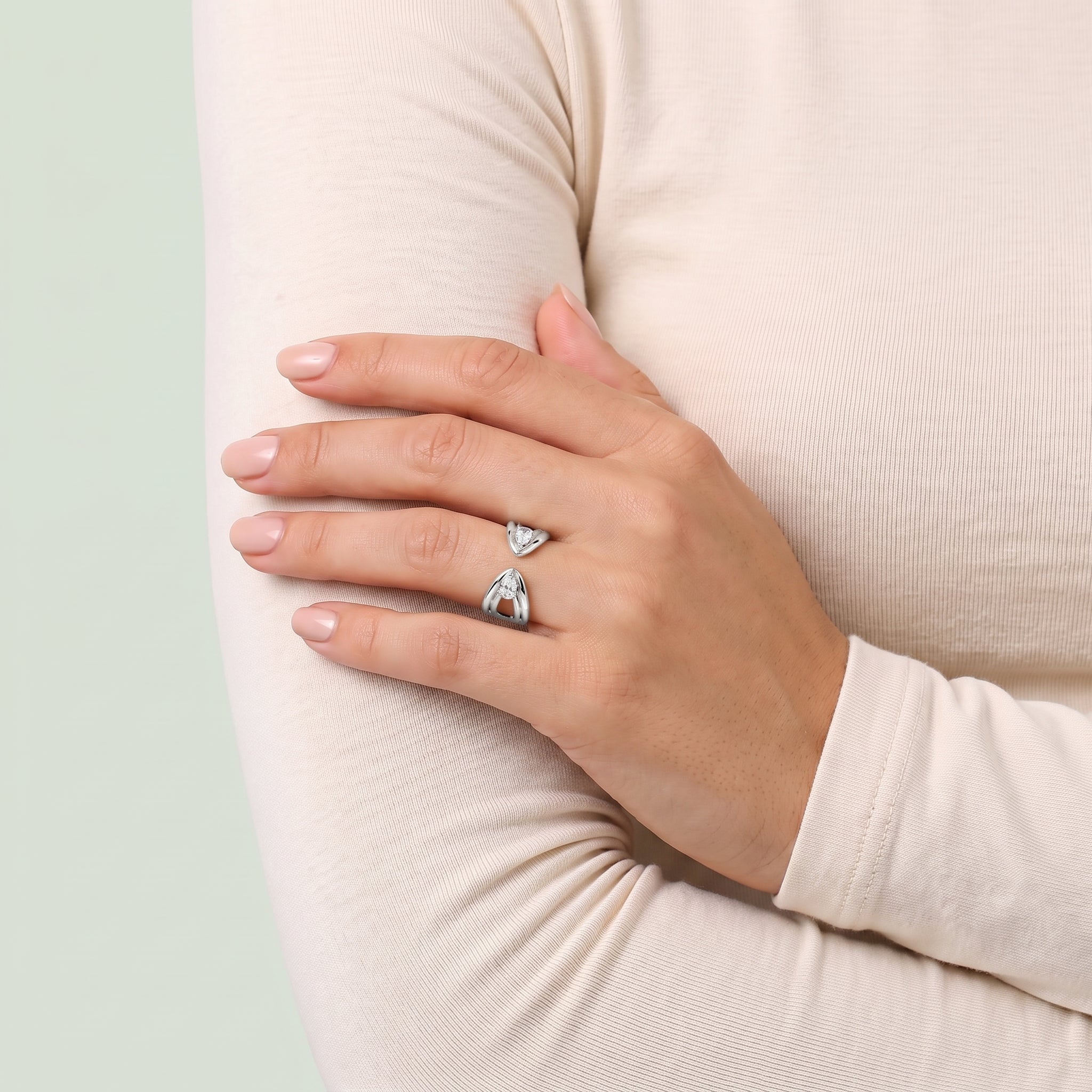Silver pear open ring on a hand resting on the arm