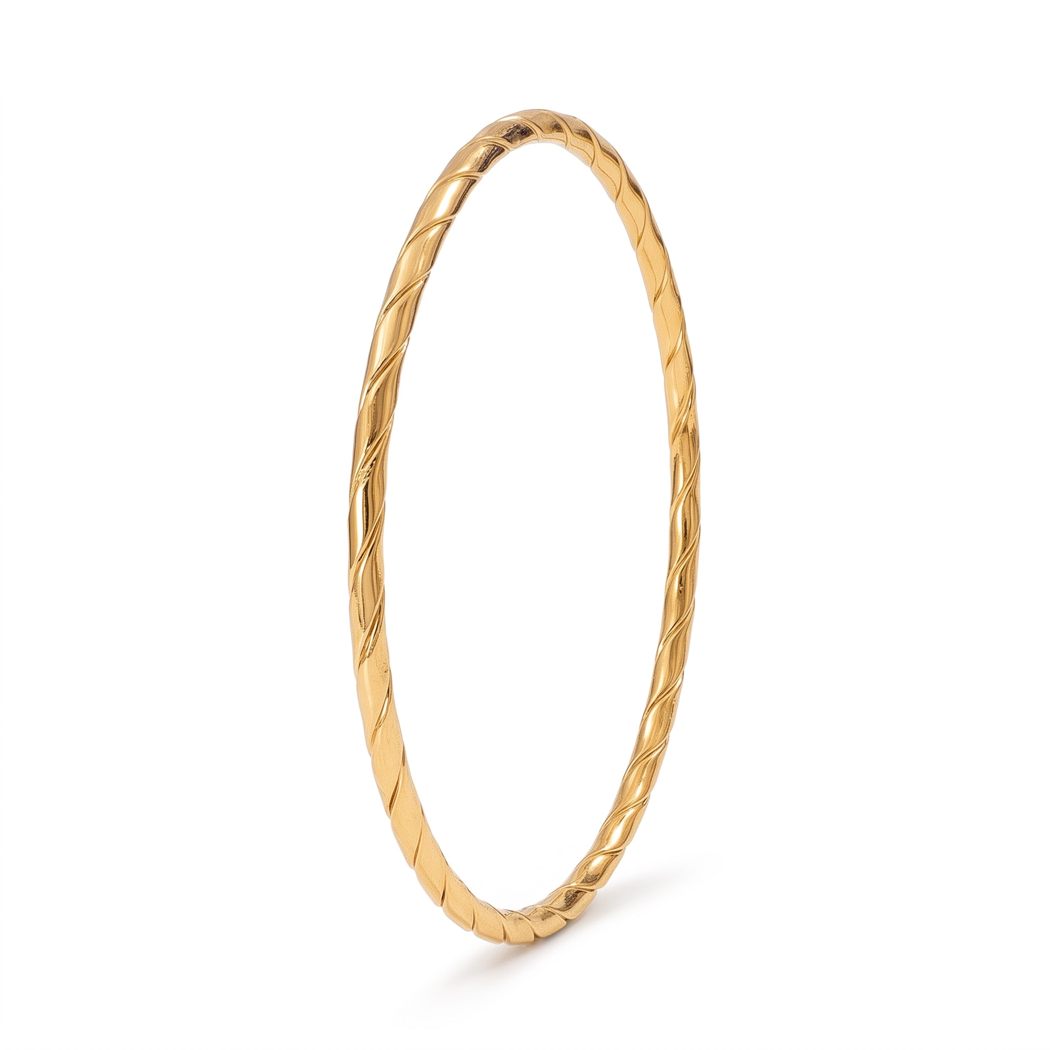 Gold twisted bangle standing upright on white