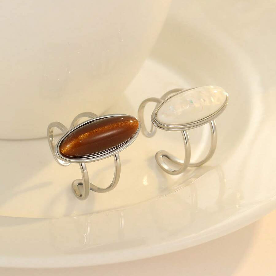 Two silver rings with gemstones on a white dish