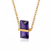 Gold birthstone necklace with a purple rectangular crystal