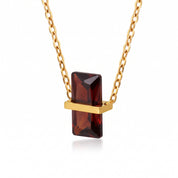 Gold birthstone necklace with a deep red rectangular crystal pendant