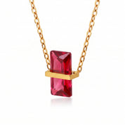Gold birthstone necklace with a bright red rectangular crystal