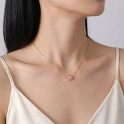 Gold birthstone necklace with a pink crystal worn at the collarbone