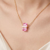 Close-up of the gold birthstone necklace's pink crystal on the skin