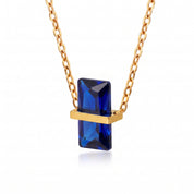 Gold birthstone necklace with a royal blue rectangular crystal
