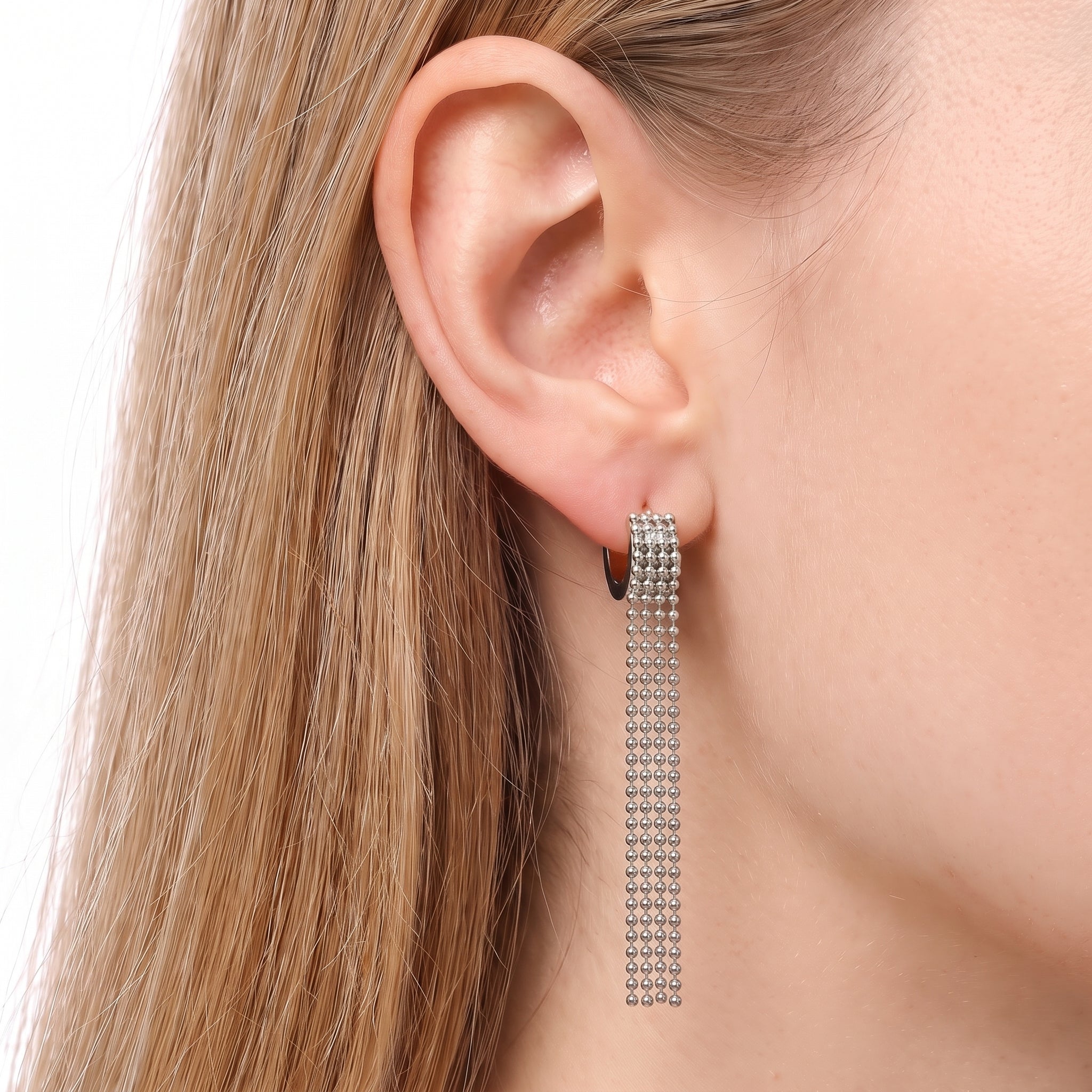 Silver ball chain tassel earrings worn on the earlobe