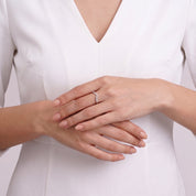Hands clasped at the waist showing Soline crystal chevron ring with white top