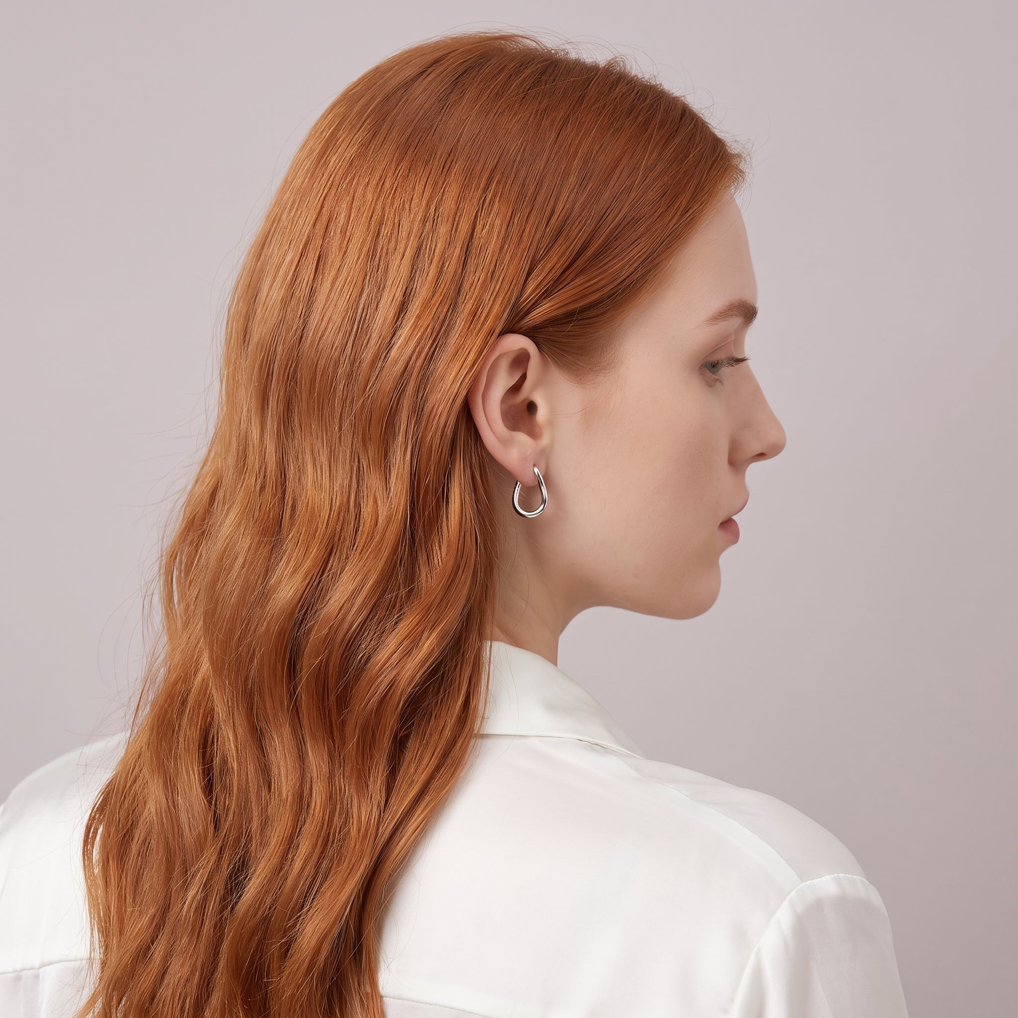 Silver twisted hoop earring seen over the shoulder